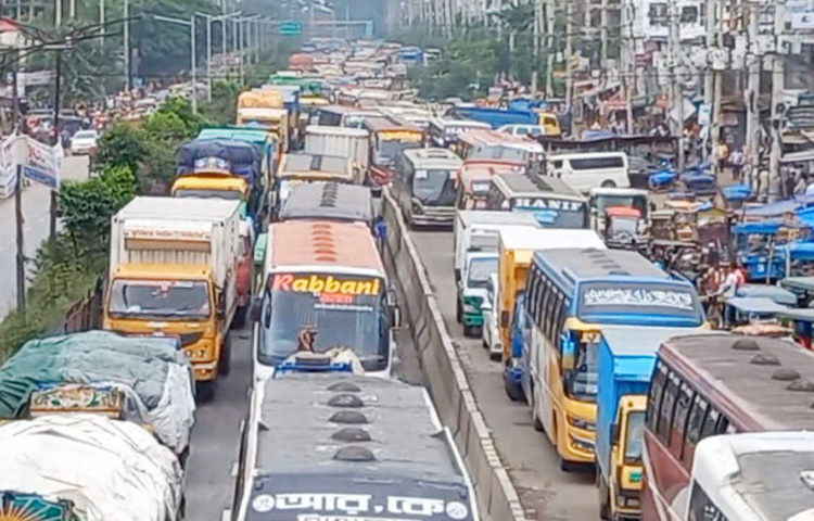 সাভারে ঢাকা রপ্তানি প্রক্রিয়াকরণ অঞ্চলসহ (ডিইপিজেড) অন্যান্য কারখানায় সমহারে পুরুষ শ্রমিক নিয়োগের দাবিতে টানা তৃতীয় দিনের মতো বিক্ষোভ করেছেন চাকরিপ্রত্যাশীরা। আজ সকালে বিক্ষোভকারীরা ডিইপিজেডের নতুন ও পুরাতন জোনের প্রধান ফটক দুটিতে অবস্থান নিয়ে বিভিন্ন কারখানার শ্রমিকদের কারখানায় প্রবেশে বাধা দেন। পরে তারা নবীনগর-চন্দ্রা মহাসড়কে অবস্থান নিয়ে বিক্ষোভ করতে থাকেন। এসময় সড়কটিতে বন্ধ হয়ে যায় যান চলাচল। প্রায় তিন কিলোমিটার এলাকাজুড়ে যানজট দেখা দিয়েছে। ভোগান্তিতে পড়েছেন সড়কে চলাচলরত যাত্রী ও পথচারীরা। ছবি- জাগো নিউজ