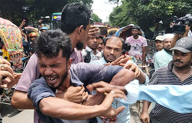 আজ (১৫ আগস্ট) বঙ্গবন্ধু শেখ মুজিবুর রহমানের ৫০তম মৃত্যুবার্ষিকী উপলক্ষে ফুলের তোড়া হাতে ধানমন্ডির ৩২ নম্বরে শ্রদ্ধা জানাতে গিয়ে হেনস্তার শিকার হয়েছেন একজন রিকশাচালক। জনরোষের মুখে তাকে গণপিটুনি দেওয়া হয়েছে। ছবি: জাগো নিউজ