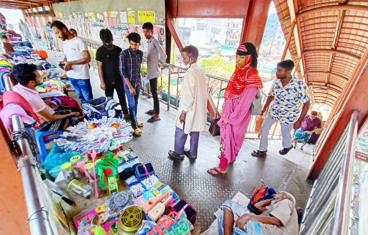 রাজধানীর বেশিরভাগ ফুট ওভারব্রিজ পথচারীদের চলাচলবান্ধব নয়। দুর্ঘটনা এড়াতে এবং পথচারীদের পারাপারে সুবিধার জন্য এগুলো স্থাপন করা হলেও এখন তা হকারদের দখলে। ছবি: জাগো নিউজ
