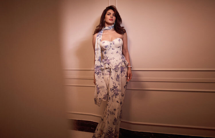 প্রিয়াঙ্কার এই লুকে অতিরিক্ত নাটকীয়তা নেই, নেই প্রচলিত হাই-গ্ল্যামার; বরং দেখা যাচ্ছে পরিমিত সৌন্দর্য, আধুনিক ভাবনা এবং ভারতীয় পোশাকের নতুন সংজ্ঞা। তিনি পরেছেন ডিজাইনার অর্পিতা মেহতার কাস্টম ফিউশন শাড়ি, যা সাধারণ শাড়ির ধারণা থেকে একটু ভিন্ন।