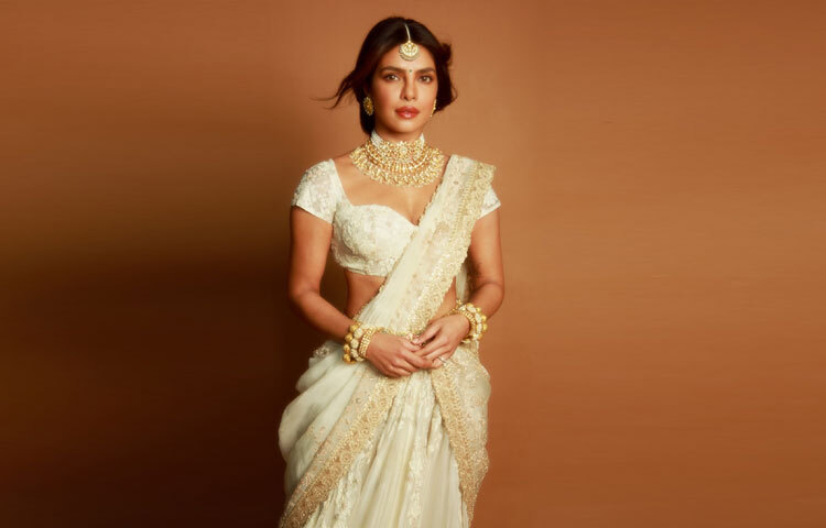 শাড়ির ব্লাউজটি হালকা স্বচ্ছ লেস–ওয়ার্কে তৈরি, যা নারীত্বের কোমলতাকে নান্দনিক এক পরিসরে তুলে ধরে। ছবিতে তার ভঙ্গিমা নীরব হলেও উপস্থিতি গম্ভীর-দৃশ্যমান এই দ্বৈততা সাজটিকে আরও জীবন্ত করে তোলে।