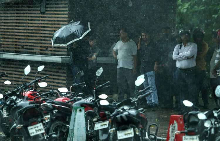 রাস্তায় হাঁটা মানুষদের ধীরে ধীরে ছাতা খুলে নেওয়া, বৃষ্টির মধ্যে ছন্দময় পদচারণা এমন দৃশ্যগুলো অচেনা শহরের ছবির মতো।