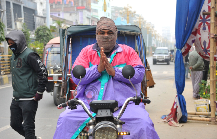 রাজশাহীতে শীতে উষ্ণতা পেতে টুপি পরে রিকশা নিয়ে বের হয়েছেন এক চালক। ছবি: সাখাওয়াত হোসেন