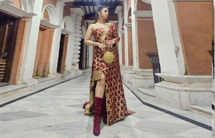 নজর কাড়ার মতো থাই-স্লিটের সঙ্গে আঁচলকে লম্বা ট্রেন আকারে সাজানো হয়েছে, যা লুকটিতে এনেছে নাটকীয় আবেদন। গয়না নির্বাচনে হৃদি রেখেছেন সাদামাটা অথচ আভিজাত্যে ভরা ছাপ। কানে সোনালি ঝুমকা, নাকে ছোট্ট নাকফুল, হাতে একগুচ্ছ চুড়ি আর আংটি।