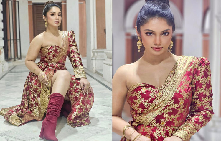 গাউনটির পাফড ফুলস্লিভ পুরো লুকটিকে রাজকীয় মাত্রা এনে দিয়েছে, আর র‍্যাপ-স্টাইলে ব্যবহার করা জমকালো কাতানপাড়ে ফুটে উঠেছে ডিজাইনারের সৃজনশীল ছোঁয়া।