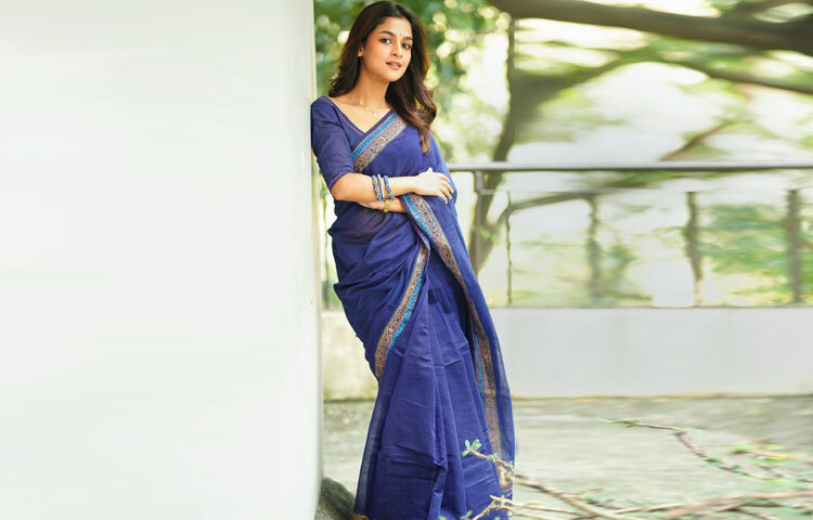 চুল মাঝসিঁথি করে খোলা, হালকা কার্লে দুলছে হাওয়ার ছোঁয়ায়। চোখে সূক্ষ্ম কাজল, ঠোঁটে হালকা ন্যুড শেডের রঙ, আর কপালে ছোট্ট টিপ সব মিলিয়ে এক নিখুঁত স্নিগ্ধতা। যেন বাংলা উপন্যাসের কোনো নায়িকা জীবন্ত হয়ে উঠেছে আধুনিকতার মোলায়েম ছোঁয়ায়।