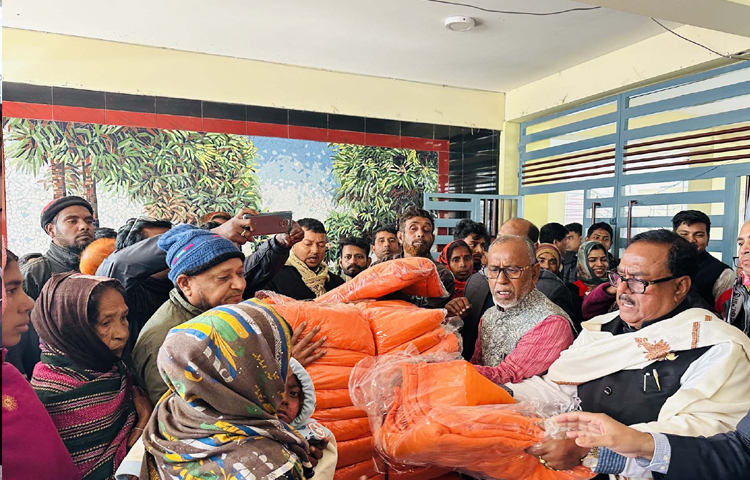 নওগাঁর নিয়ামতপুর উপজেলা পরিষদ চত্বরে শীতার্ত মানুষের মাঝে কম্বল বিতরণ করেন খাদ্যমন্ত্রী সাধন চন্দ্র মজুমদার। ছবি: পিআইডি