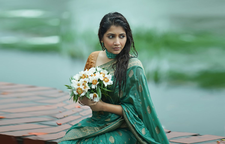 সবুজ-নীলের মিশেলে তৈরি সমুদ্র-সবুজ রঙের সিল্ক কাতান শাড়ি, যার পাড়জুড়ে ঝলমলে রূপালি জরির কারুকাজ। আঁচল ও বুটিতে ছড়ানো রুচিশীলতা তার লুকটিকে করেছে আরও অনবদ্য।