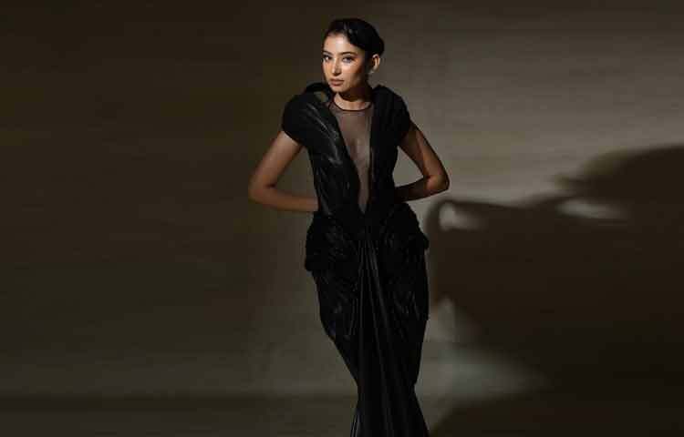 কালো রঙ এখানে শোকের নয়, ক্ষমতার। আলো পড়লে কাপড়ের টেক্সচার চকচক করে ওঠে, আবার ছায়ায় মিলিয়ে যায়; যেমন সারা নিজে, ক্যামেরার সামনে থাকলে দৃশ্যমান, নীরব থাকলে রহস্যময়।