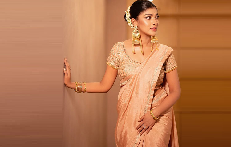 চুল টেনে বাঁধা স্লিক খোঁপায় সাদা গাজরা এনে দিয়েছে শুদ্ধতার ছোঁয়া।