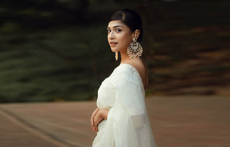 সাদা শাড়ির সঙ্গে সবচেয়ে বেশি নজর কেড়েছে তার কানের দুল।