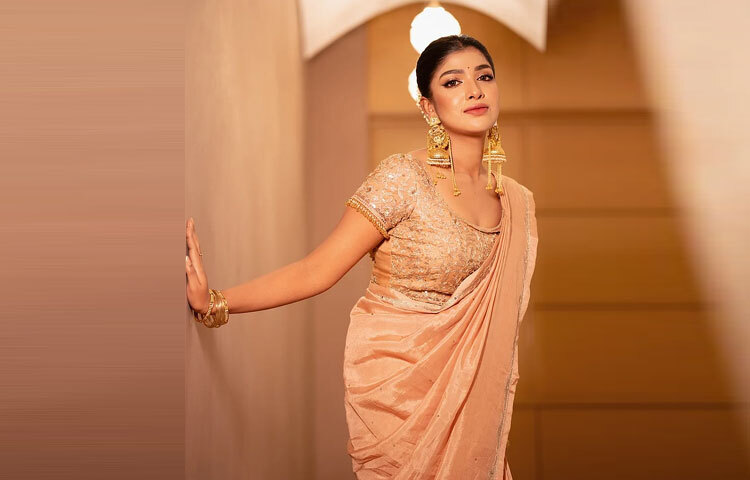 নিখুঁত ড্রেপিং সারিকার ফিগারকে করেছে আরও আকর্ষণীয়। সঙ্গে ছিল ডিপনেক ব্লাউজ, যা সোনালি জরির কারুকাজে ঝলমলে হয়ে উঠেছে।