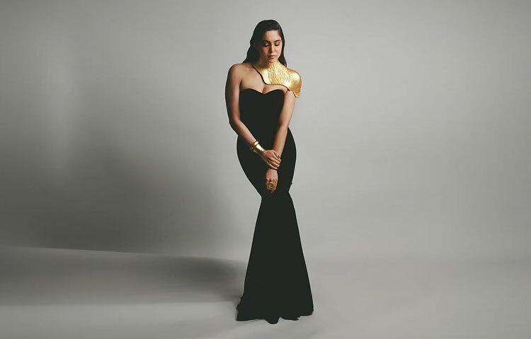 স্ট্র্যাপলেস গাউনের সঙ্গে তিনি মিলিয়েছেন সোনালি স্টেটমেন্ট অনুষঙ্গ। হাতে পরেছেন ভারী কাফ ব্রেসলেট, কানে স্টাইলিশ ইয়ারকাফ আর গলার বর্ম-স্টাইল নেক প্লেটটি পুরো সাজে এনেছে রাজকীয় আবেদন।