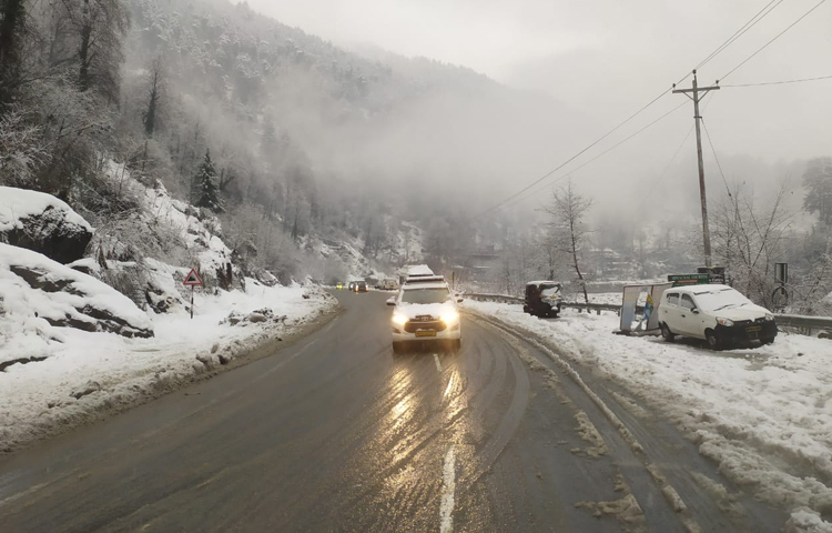 দুপাশে বরফে ঢাকা সব। মাঝ রাস্তা দিয়ে ছুটে চলছে যানবাহন। ছবি: সাইফুল উদ্দিন