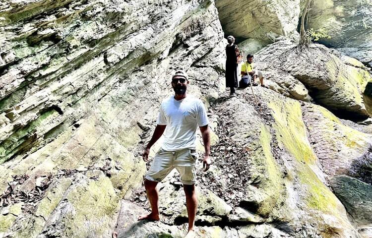 এরপর কিছুটা পথ ঘুরে এসে আবারো হাইকিং-ট্র্যাকিং। একের পর এক বেশ বড়সড় পাথুরে বোল্ডার অতিক্রম করতে হবে। কিছুক্ষণ আগে যে গুহার ভিতরে ছিলেন এখন সেই বাদুইজ্জাখুমের ঠিক উপরেই। দৃষ্টির খুব কাছাকাছি হাজার হাজার বাদুড়ের উড়াউড়ি। ছবি: এম মাঈন উদ্দিন