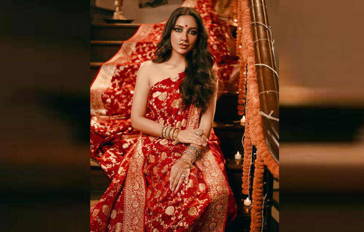 বাঙালি নারীর উৎসবের সাজে লাল বেনারসি শাড়ি চিরকালীন ঐতিহ্য। শুভশ্রী এই ঐতিহ্যকেই বেছে নিয়েছেন নিজের পূজার লুকে। ঝলমলে লাল বেনারসির জমিনে সোনালি জরির কাজ, তার সঙ্গে সোনালি পাড়-পুরো শাড়ির গঠনেই ফুটে উঠেছে রাজকীয় আমেজ। এমন সাজে তাকে দেখে মনে হয়েছে, যেন পূজামণ্ডপে প্রতিমার বাইরে জীবন্ত হয়ে উঠেছেন এক দেবী।