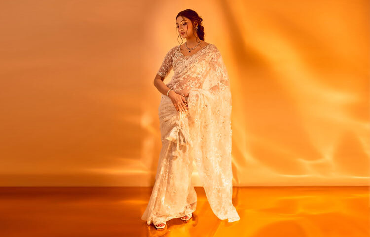 পায়ে ছিল মানানসই সাদা স্যান্ডেল, আর হাতে ধরা ব্যাগ পুরো সাজে যোগ করেছে সম্পূর্ণতা।