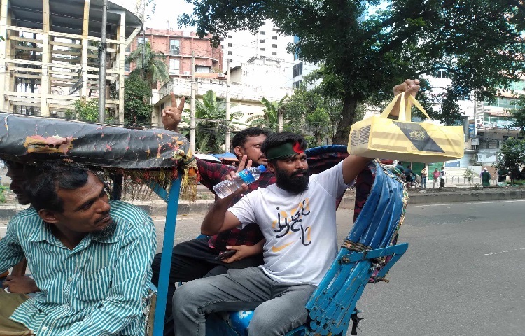 বিজয়ের খুশিতে মিষ্টি বিতরণ করছেন সাধারণ মানুষজন। ছবি: নাজমুল হোসেন বাপ্পি