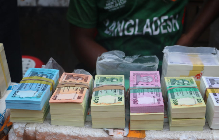 একেকটি ব্যান্ডেলে ১০০টি করে নোট থাকে। প্রতি ব্যান্ডেল ১০০ থেকে ২০০ টাকা করে বেশি নেওয়া হচ্ছে। ছবি: মাহবুব আলম