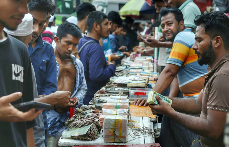 টাকার পসরা সাজিয়ে বসেছেন দোকানিরা।