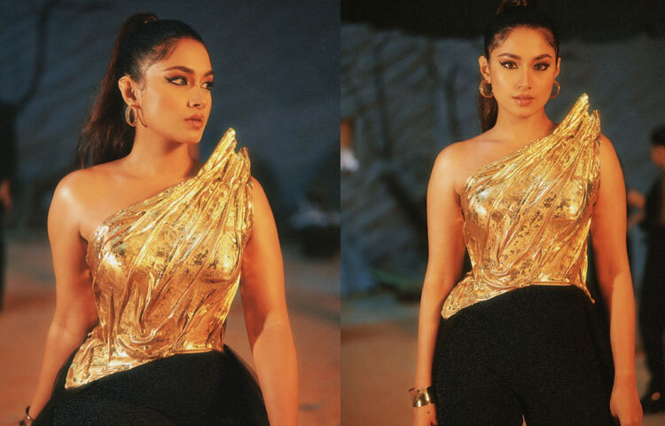 পোস্টারে ফারিণের লুক এক নজরেই ভক্তদের দৃষ্টি আকর্ষণ করে। পরেছেন কপার–গোল্ড মেটালিক ব্রেস্টপ্লেট টপ, চুল বাঁধা উঁচু পনিটেলে, কানে ঝুলছে গোল্ড হুপ দুল আর মেকআপে কাজল দেওয়া চোখ যেন আরও প্রাণবন্ত করে তুলেছে তার উপস্থিতি।