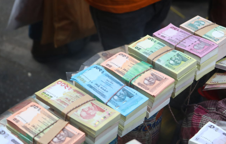 ঈদ উপলক্ষে গুলিস্তানের ভ্রাম্যমাণ দোকানীর কাছ থেকে নতুন টাকা সংগ্রহ করছেন সাধারণ মানুষ। ছবি: মাহবুব আলম