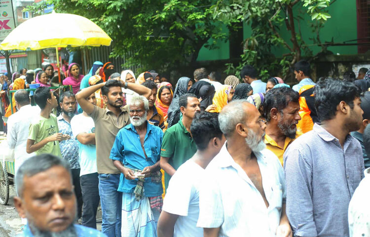 রোদ, গরম কিংবা ধুলোবালিকে উপেক্ষা করে এক টুকরো স্বস্তির আশায় দাঁড়িয়ে আছেন নারী-পুরুষ থেকে শুরু করে বয়স্ক মানুষও।