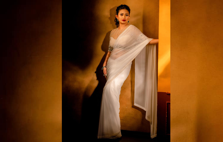 স্টেটমেন্ট ব্লাউজের সঙ্গে নজর কাড়ছে শাড়ির চিকন পাড়জুড়ে মুক্তার কারুকাজ।