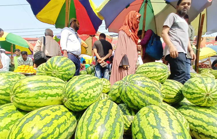ইফতারের আগে কারওয়ান বাজারে বাজার করার পাশাপাশি তরমুজের দর দাম করছেন অনেকেই। তবে কিনতে পারছেন অল্প কিছু মানুষ। ছবি: মাহবুব আলম