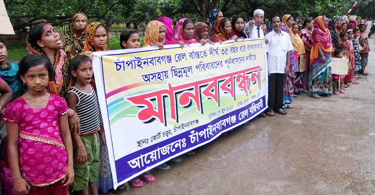 চাঁপাইনবাবগঞ্জে রেলওয়ে বস্তিবাসীদের পুনর্বাসনের দাবিতে মানববন্ধন