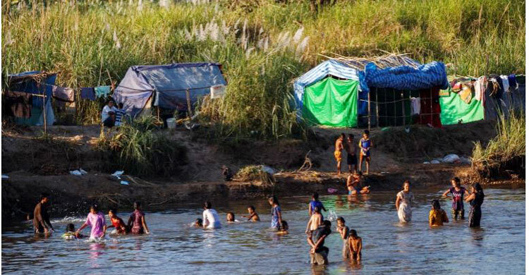 Fleeing violence in Myanmar, thousands camp along Thai border river