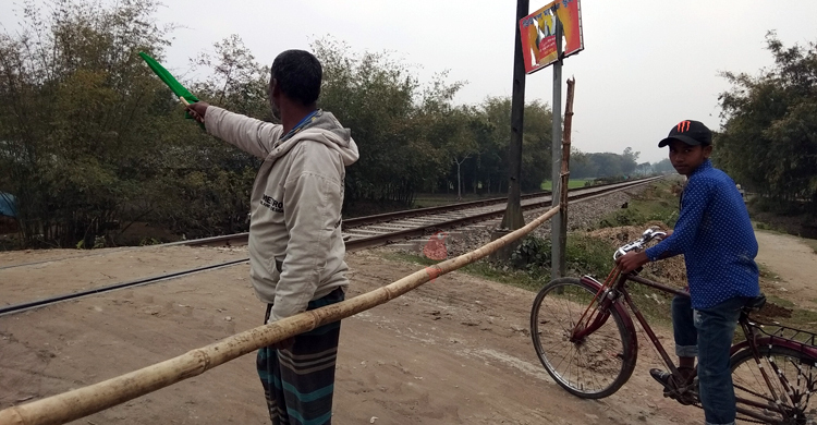 দুর্ঘটনা এড়াতে বাঁশের ব্যারিকেড দিয়ে রেলগেট পাহারা দেন আলমগীর