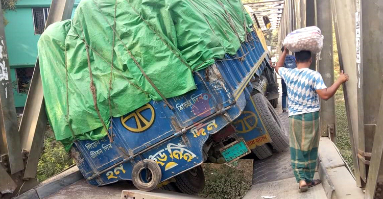 বেইলি ব্রিজের পাটাতন ভেঙে মাঝখানে আটকে গেছে সরিষাভর্তি ট্রাক