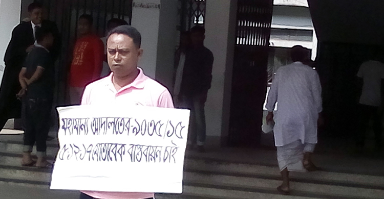 গলায় প্ল্যাকার্ড ঝুলিয়ে ডিসি কার্যালয়ের সামনে একক প্রতিবাদ