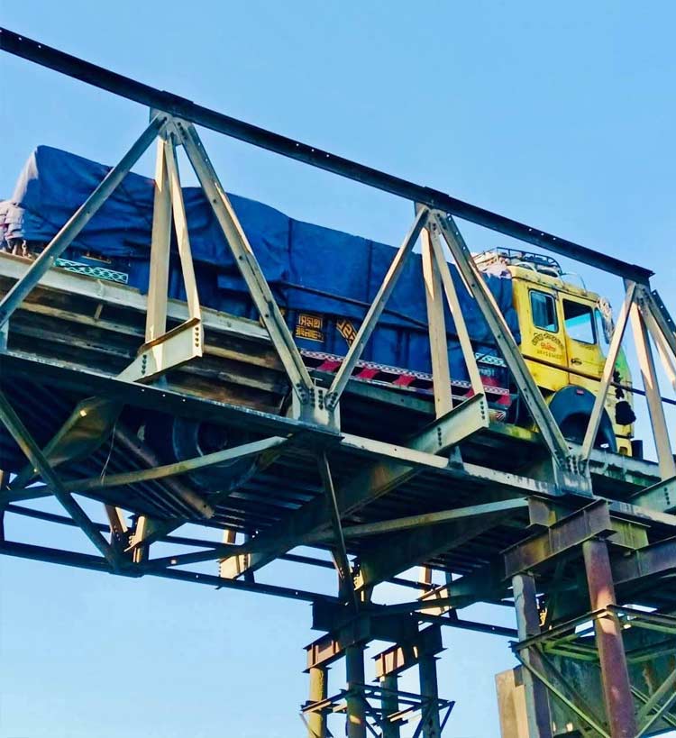 বেইলি সেতুর পাটাতন ভেঙে ঝুলে আছে ট্রাক, যোগাযোগ বন্ধ