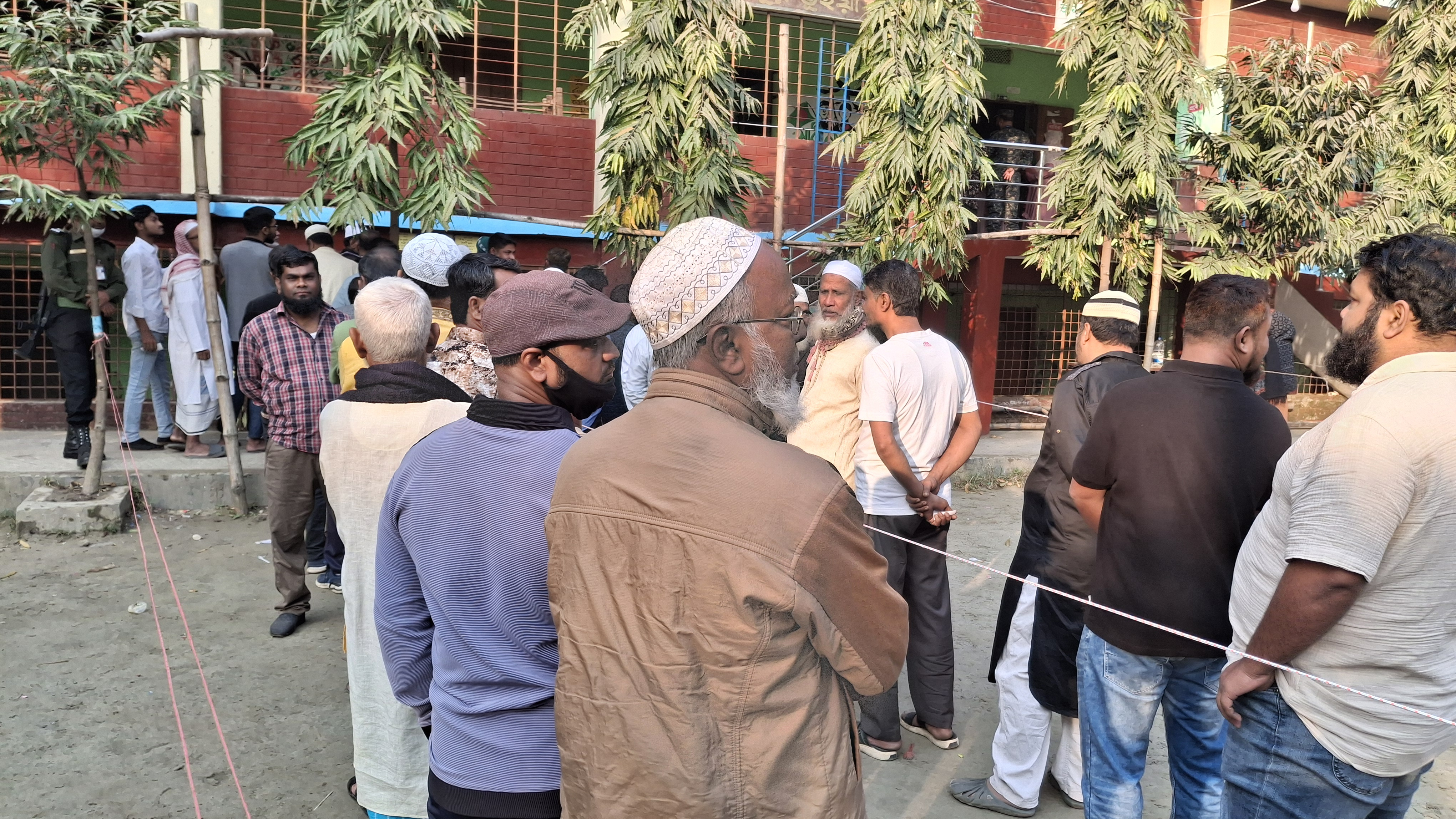 যাত্রাবাড়ীর মাতুয়াইল বহুমুখী উচ্চ বিদ্যালয় কেন্দ্রে লাইনে দাঁড়িয়ে আছেন ভোটাররা