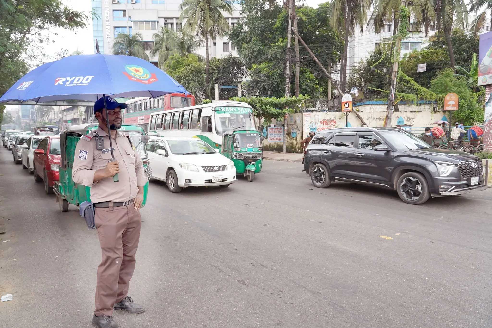 ট্রাফিক পুলিশ সদস্যদের মধ্যে ছাতা বিতরণ করল রাইডো