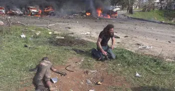 Syrian photographer stops taking pictures, picks up injured boy