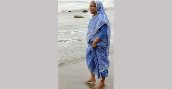 PM walks barefoot on the beach 