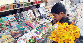 প্রচ্ছদে চোখ বুলিয়ে মেলায় পথশিশুদের বইপড়া
