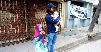 সাত মাসের সন্তান কোলে বাইরে বাবা, ভেতরে ভোট দিচ্ছেন মা